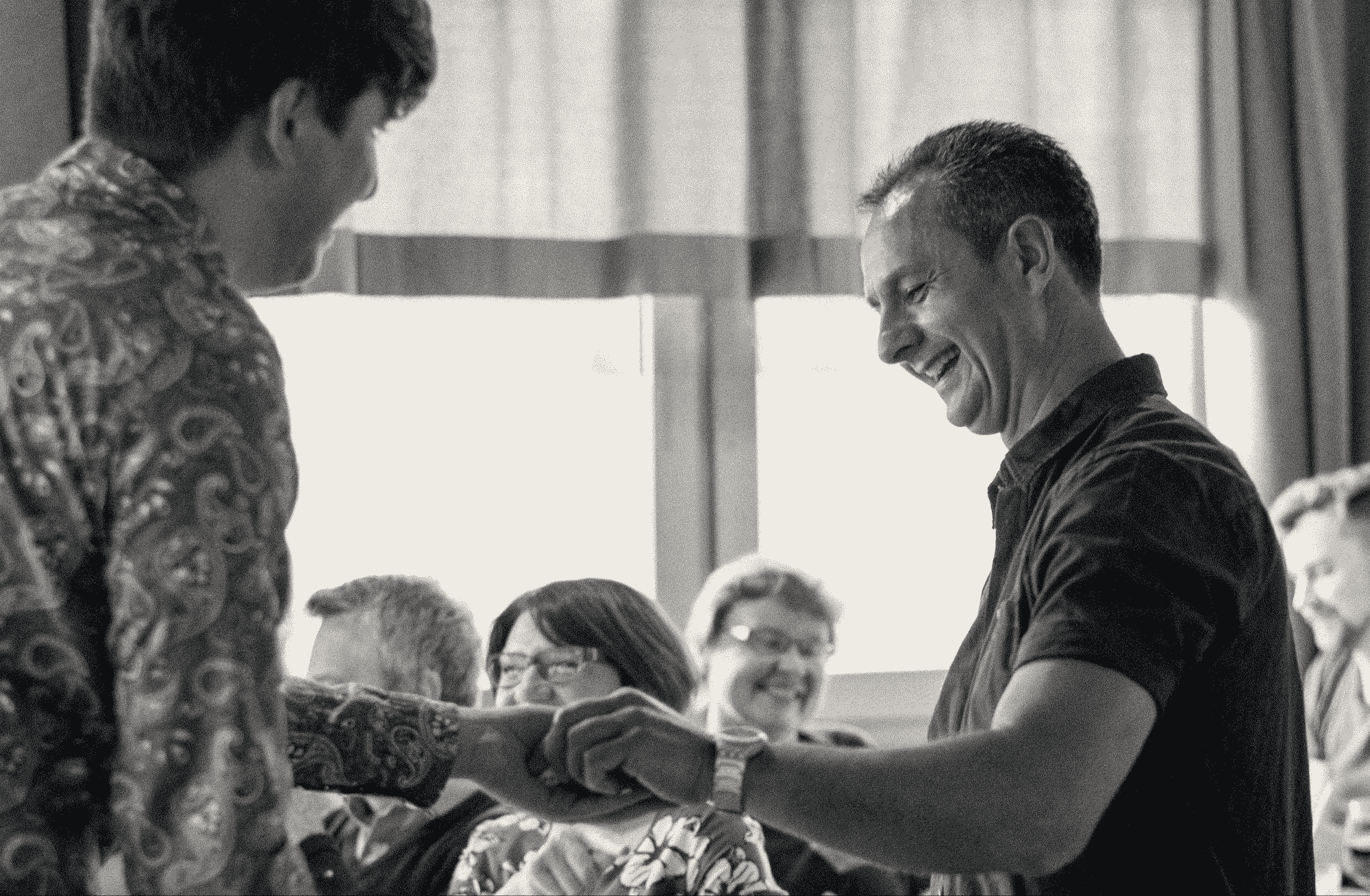 Mann nimmt einen Würfel aus TOMs Hand.